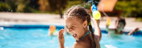 Niña jugando en la piscina